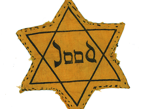 Auf einem gelben sechseckigen Stern aus Stoff steht »Jood« geschrieben.